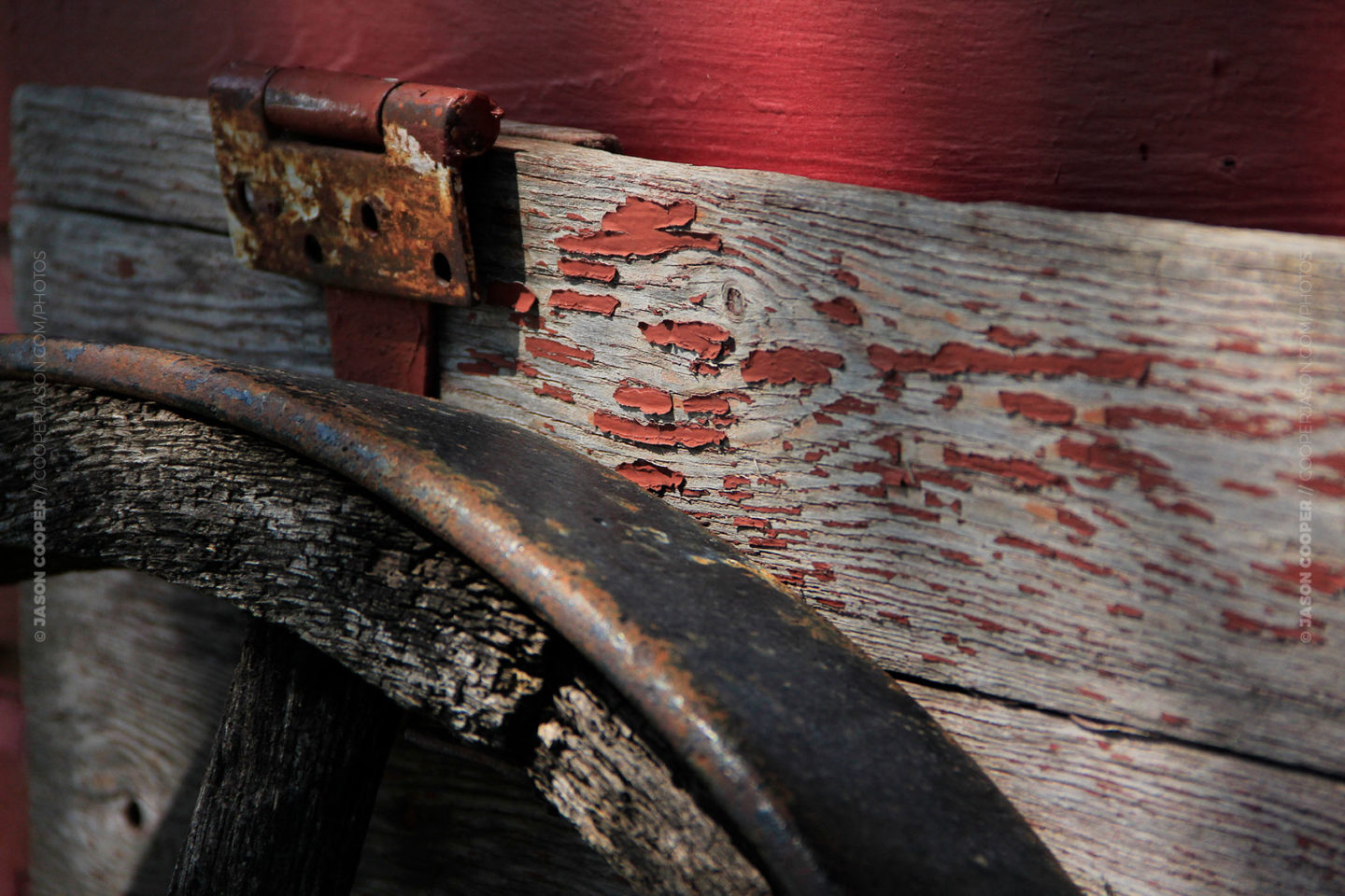 photo of a rusty red hinge and a wagon wheel