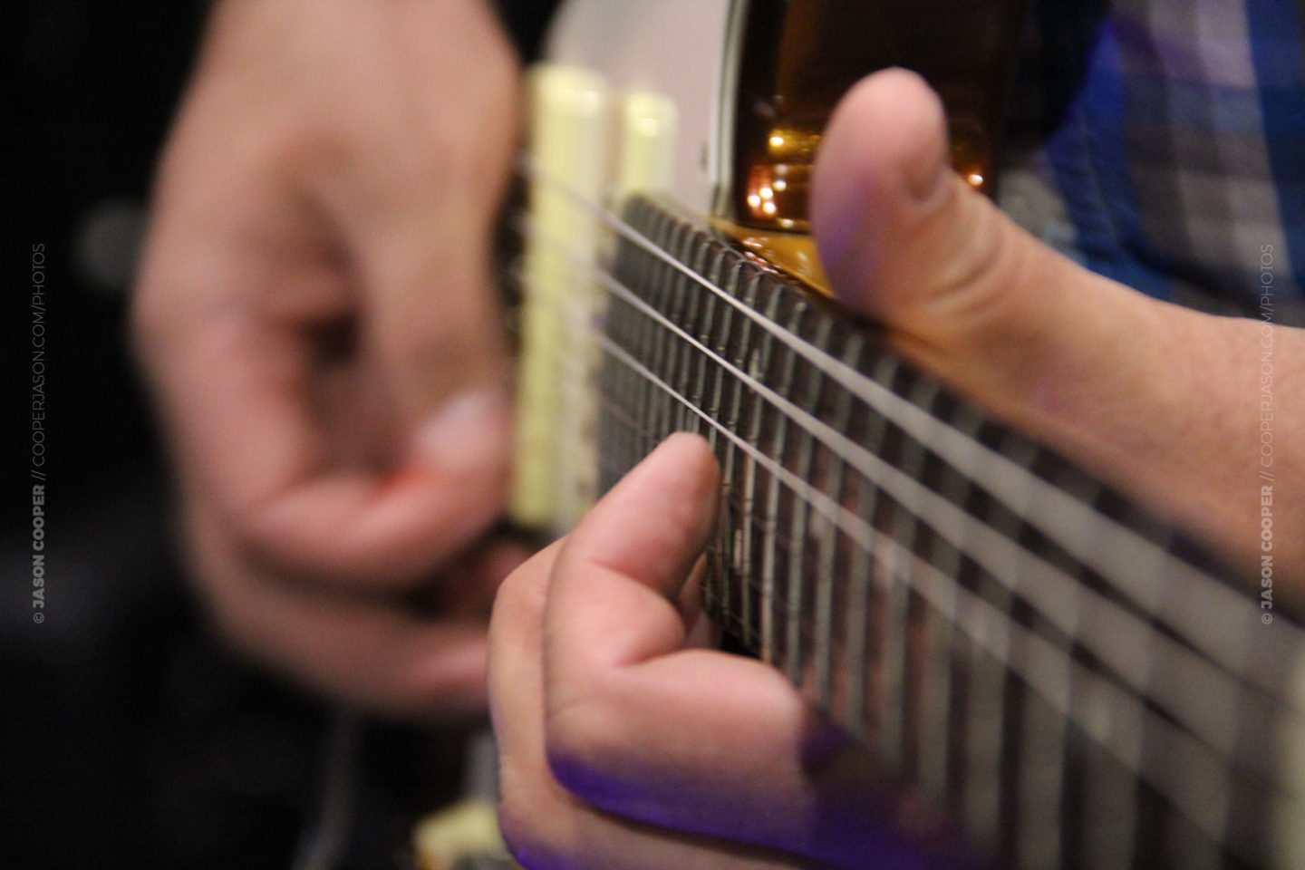 close up photo of musicians hand playing a worship team guitars